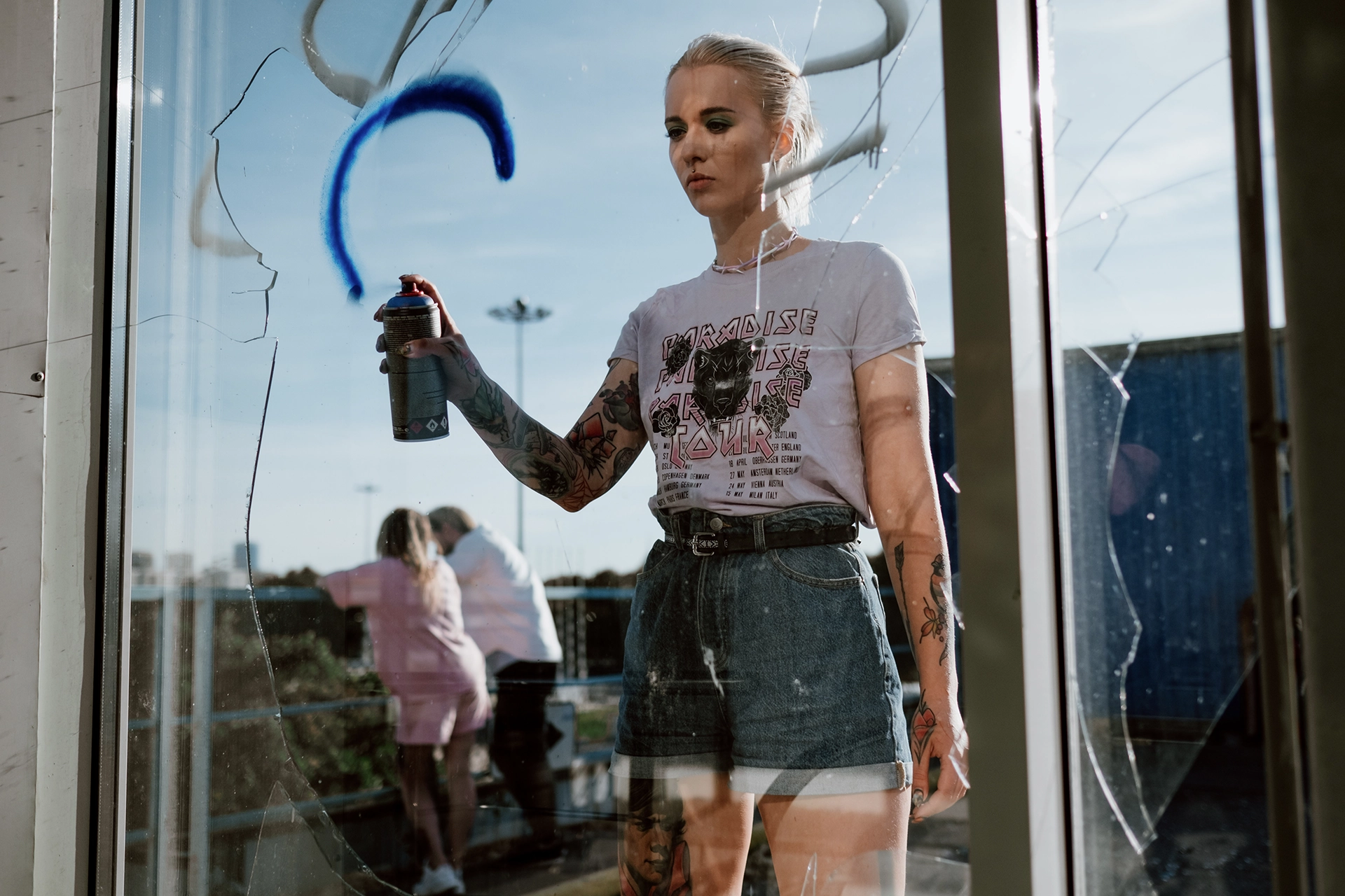 donna che fa graffiti su vetro rotto